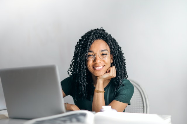 woman smiling behind laptop